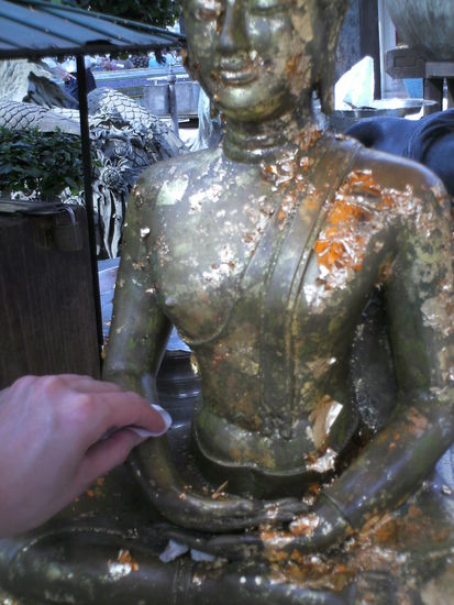 Blattgold auf Buddhafiguren druecken soll Glueck bringen