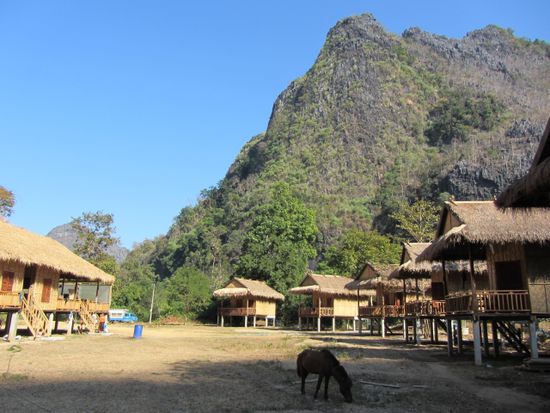 Mr. Ling posiert vor den fertig gebauten Bungalows