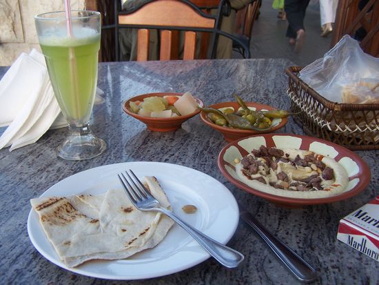 Sowas ist lecker und besteht aus Chapati, Kichererbsenbrei, Lamm, Oliven und Peperoni. Das Getränk besteht aus Wasser, Zitrone und Minze. Sehr erfrischend !