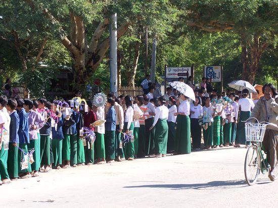 Schüler nehmen Aufstellung für ein buntes Fest. Den Mönchen werden heute Geschenke gemacht.