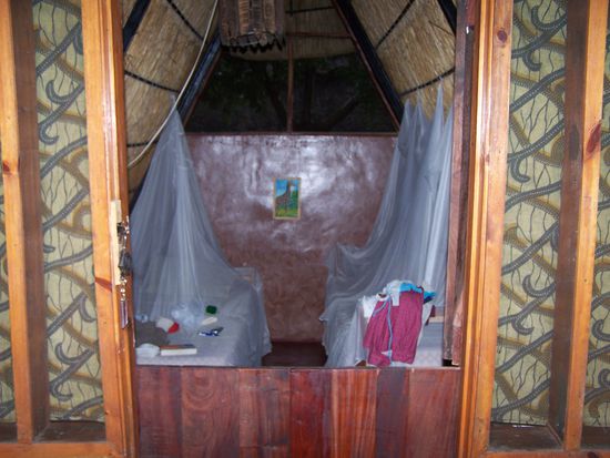 Wie ungewohnt: Ein Bett mit Moskitonetz in einer festen Behausung !