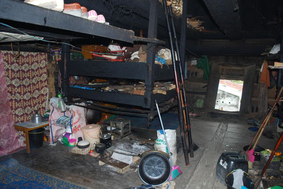 8 Familien unter einem Dach - für jede ist eine solche Feuerstelle mit "Vorratsregal" darüber und Schlafmatte daneben vorhanden. Es ist düster, verrusst und eng, aber kühl.