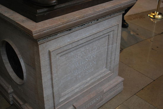 Der Sockel der Statue von Ronald Reagan. Zwischen der Sockelplatte und dem helleren Sockelkörper befindet sich ein ca. 1 cm schmaler Streifen aus buntem Gestein. Was das ist ? Etwas besonderes: Dieser Streifen ist aus Berliner Mauer gemacht !