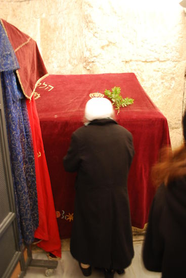 Alte Dame betet versunken im Frauenbereich