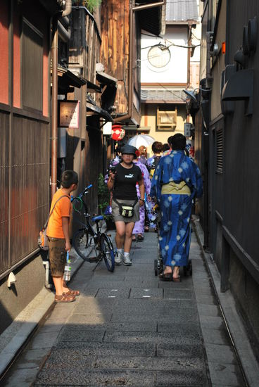 Echte Geishas und Meikos verlassen nahezu niemals ihre Unterkünfte in Berufskleidung, weil sie dann gnadenlos zum Foto-Abschuss freigegeben wären. Deswegen einzige Chance frühabends, wenn einige von ihnen schnellstmöglich zu den Teehäusern huschen.