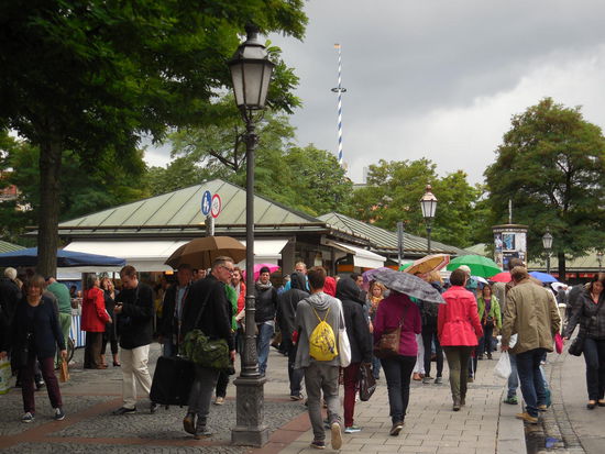trubeliges Markttreiben in München. Selbst ich Nordlicht, die ich gerade vor Hunger umkomme, habe schon vom "Schlemmermeyer" gehört. Da gibt es vernünftige Bratwurst und eine selbige ziehe ich mir rein. Die Bratwurst heißt anders, als bei uns, sieht aber genauso aus. Und schmeckt auch genauso. Mit Senf und Ketchup. Den Namen der Bratwurst habe ich vergessen, das war zu exotisch, um es zu behalten. Zumindest heißen Thüringer hier auch "Thüringer", aber ich habe ja die andere genommen, die rote...