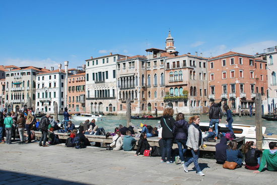 scheinbar beliebter Treffpunkt in Rialto: In den umliegenden Bars und Cafés kann man sich z.B. einen Aperol Spritz im Plastikbecher kaufen und dann direkt am Canale Grande die Beine baumeln lassen.
