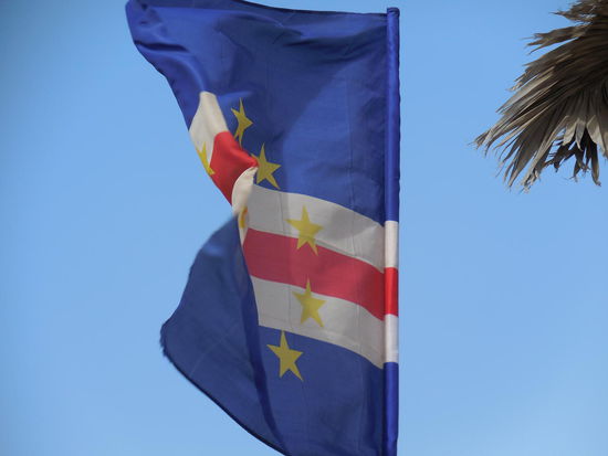 Die moderne Flagge der Republik Cabo Verde - es gibt sie so erst seit 1992 und ist vielen Einheimischen zu un-afrikanisch. Bis 1992 ähnelte die Flagge derjenigen von Guinea-Bissau und war rot/grün/gelb. Da man sich mit dem ehemaligen "Freund" Guinea-Bissau jedoch zerstritten hatte, wurde auch die Flagge geändert, die jetzt viel europäischer aussieht. Die 10 Sterne repräsentieren die Inseln, das Blau oben und unten den Himmel und das Meer, die weißen und der rote Streifen stehen für Einigkeit und Hoffnung.