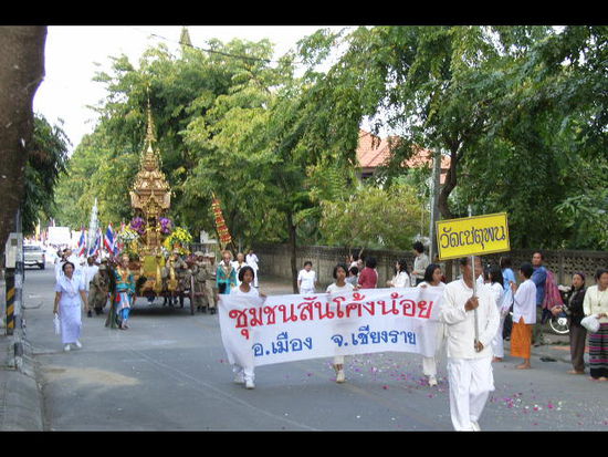 umzug am 31. in chiang rai. sehr viele frauen in weisser kleidung und unzaehlige buddhastatuen auf wagen.