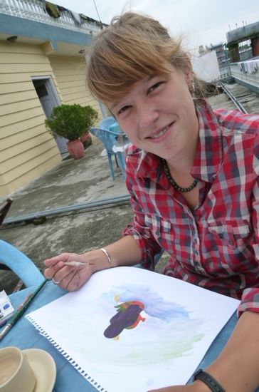 Person C am Malen eines Bilderbuches