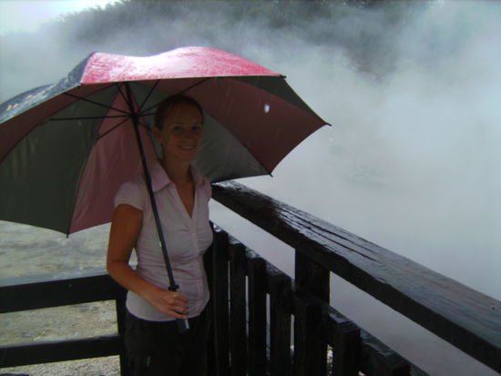 Sabina im stroemenden Regen vor einer dampfenden Quelle im "Hells Gate"