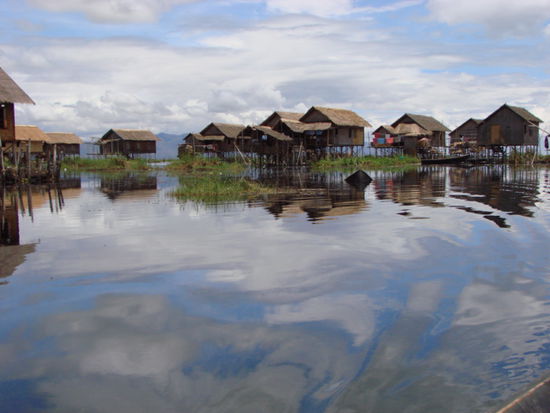 auf dem see sind sehr viele pfahlbauhaeuser zu sehen