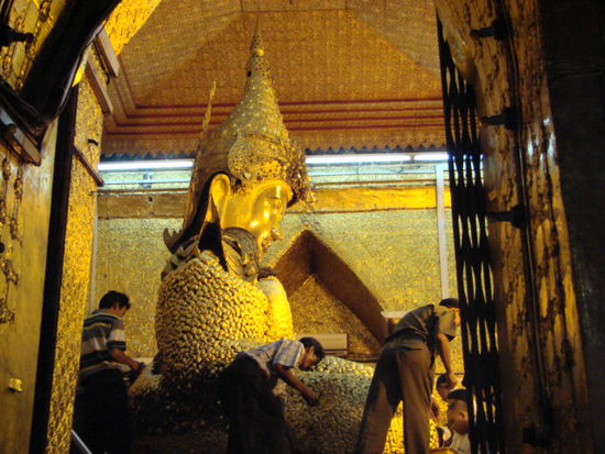 die buddhas duerfen nur von den maennern mit goldblaettchen beklebt werden.