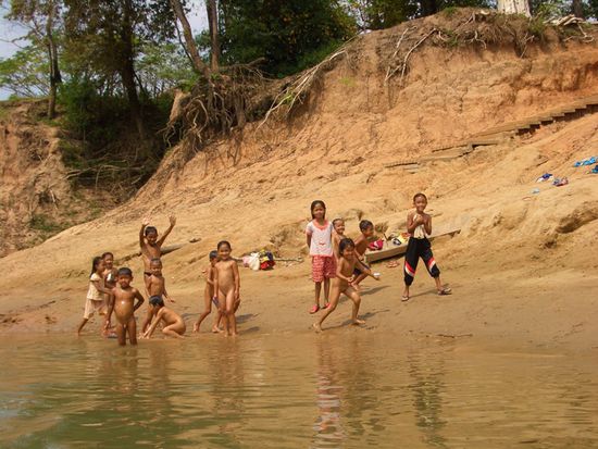 winkende Kinder am Fluss