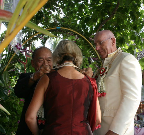 Der Praesident vom Krabi Resort legt uns den Hochzeitsschmuck an