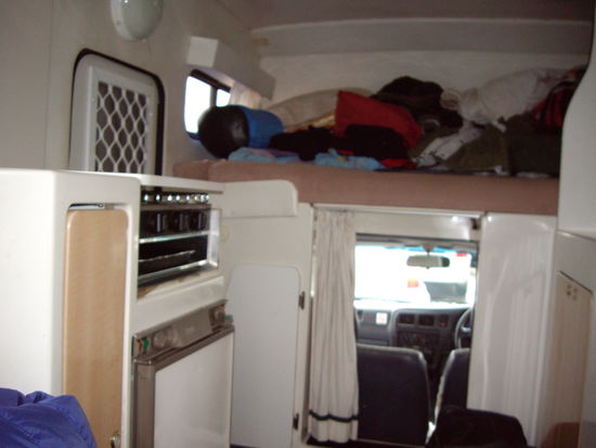 Innenansicht!links, kl. vorratskammer, kuelschrank(der immer gestunken hat),kochplatte und herd. rechts (leider nicht ganz im bild) spuelbecken, stauraum. geradeaus, fahrerkabine und bett fuer 2 personen!!!gleichzeitig stauplatz waehrend der fahrt!