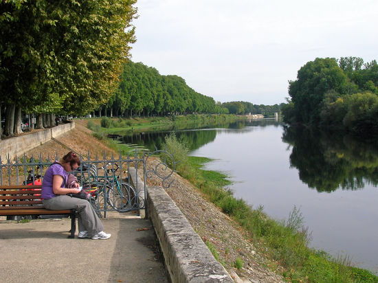 Schöne Spazierwege und Bänke an der Vienne in Chinon laden diese Frau zum Verweilen ein.