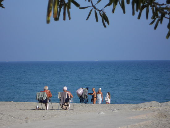 Ceriale - An dem kleinen Mini-Strand tummeln sich einige Sonnenanbeter, ältere Leute machen einen Strandspaziergang.