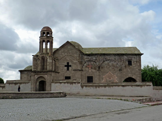 Weiter nach Derinkuyu. Oberirdisch ist dies ein ödes, graubraunes anatolisches Städtchen. Eigentlich wollten wir uns dort die armenische Basilika aus dem Jahr 1858 ansehen. Der wuchtige, von einer Mauer umgebene dreischiffige Bau wurde im 20. Jh. von griechischen Christen übernommen und nach deren Vertreibung als Lagerhaus und Mühle verwendet. Abgetrennt von der Basilika steht der Glockenturm, auf dem meist Störche nisten. Leider ist die Kirche geschlossen