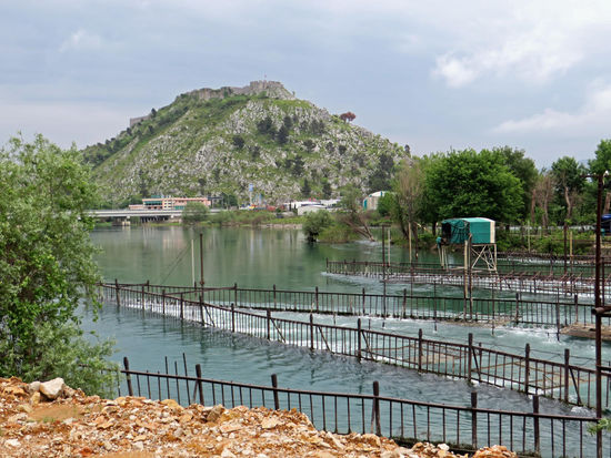 Albanien. Viele schöne bunte Häuser sind zu sehen und an der Drin gibt es Fischreusen und eine Burg auf einem Felsen zu bestaunen.