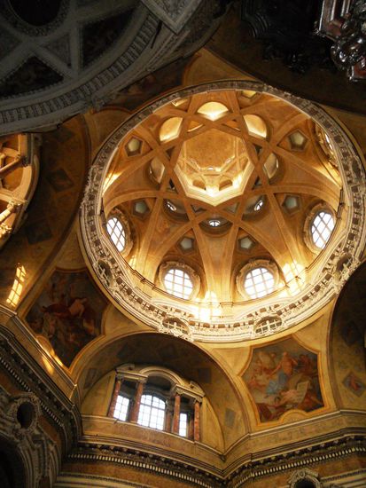 Kirche San Lorenzo - Die Kuppel fällt auf. Sie ist der Clou, sorgen doch ihre Öffnungen für wechselnde Lichteffekte. Wer drinnen genauer empor schaut, erkennt ein böses Gesicht. Nur ein Zufall? "Manche meinen, der Teufel blicke von oben herab," flüstert Stadtführerin Emanuela Moroni.