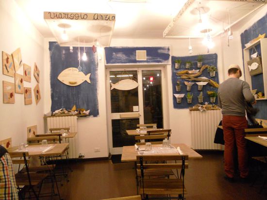 Der Weg führt uns über die Via Roma, Piazza San Carlo, Piazza Castello in die Via Garibaldi, weiter Via Bellezzia und dort zum Restaurant Pippo Paranza. Ein etwas abenteuerlich aussehendes Lokal, leider gibt es nur Fischgerichte, was Alex nicht so wirklich glücklich macht. Wir haben dort einen Tisch reserviert und so entschließen wir uns, auszuprobieren, was die Küche bietet. Die Inneneinrichtung ist spartanisch, dekoriert mit Muscheln, einfache Tische und Stühle. Der nette Inhaber ist sehr freundlich. Es gibt eine Tafel, auf der die wenigen Gerichte notiert sind.