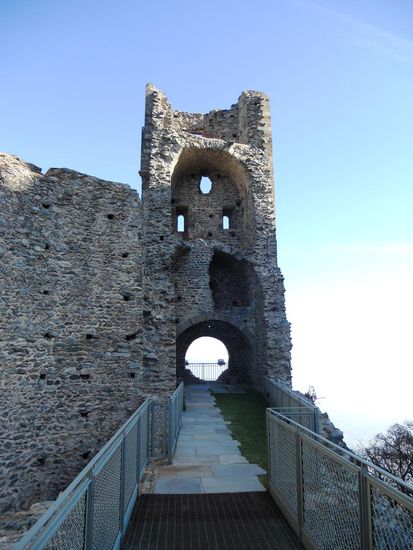 Durch das Portale die Monaci (13. Jh.) - das Mönchsportal kommen wir auf die Terrasse. Von hier haben wir einen guten Blick auf die Ruinen des neuen Klosters (12. - 14. Jh.), den etwas abgesonderten Turm der schönen Alda - Torre della Bell'Alda - und den unvollendeten Kirchturm (12. Jh.).
Die Legende erzählt, dass die schöne Alda auf der Flucht vor Soldaten von dort in den Abgrund gesprun-gen ist. Doch ein Engel rettete sie und verhalf ihr zu einem guten reichen Leben. Ein anderes, böses Mäd-chen wollte es ihr gleich tun, doch sie überlebte den Sprung in den Abgrund nicht.