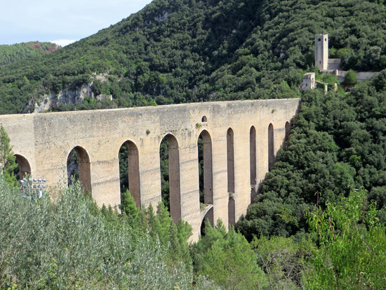 Spoleto - Unterhalb der Burganlage liegt das berühmteste Bauwerk der Stadt, die Brücke der Türme – Ponte delle torri. Die Brücke wurde im 13 Jh. auf den Grundmauern eines römischen Aquäduktes erbaut