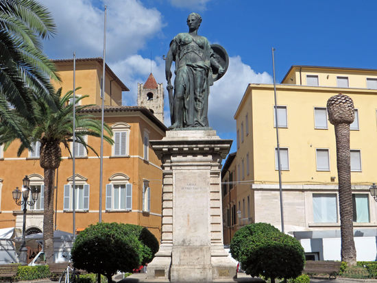 Ascoli Piceno - Weiter geht unser Spaziergang zur Piazza Roma. Heute findet hier ein Markt statt. Viele Menschen sind unterwegs. Der Platz wird von einem mächtigen Kriegerdenkmal überragt – Monumento dei Caduti.