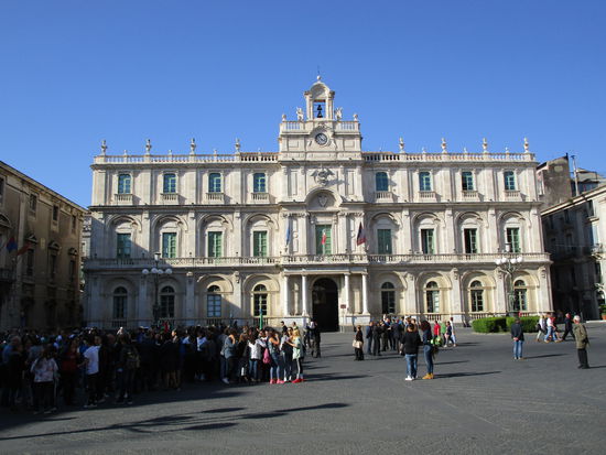 Der Palazzo dell' Università beherbergt die Verwaltung der 1434 von Alfons von Aragon (1396-1458) gestifteten Universität. Die Universität von Catania ist eine der ersten Universitäten auf dem europäischen Kontinent. Die Fakultäten befinden sich heute in den umliegenden Palazzi. Mit rund 60.000 Studenten ist sie die größte Universität Siziliens. Das 1696 fertig gestellte Gebäude stammt von Giovanni Battista Vac-carini (1702-1768). Vaccarini schuf die beiden Stockwerke des Innenhofs, den Säulengang und den zwei-farbigen Bodenbelag. Über dem Eingang steht die ursprüngliche Bezeichnung „Siculorum Gymnasium”.