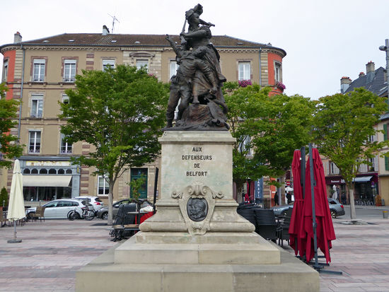 Das Denkmal Quand-Même ist ein Werk von Mercie – 1884. Das Denkmal stellt eine Elsässerin während der Belagerung von 1870/71 dar, die einen sterbenden Soldaten in ihren Armen hält. — – hier: Place d'Armes.