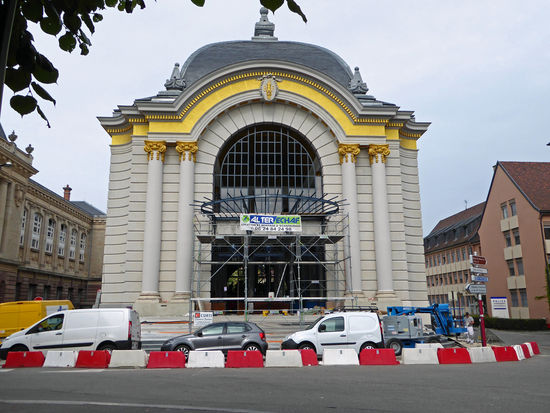 Die elegante Barockfassade des Festsaals erhebt sich seit 1913 neben dem Justizpalast. Das Gebäude steht an der Stelle einer ehemaligen, 1766 errichteten Reitanlage, die als Trainingsort für die Reiter der Garnison diente. Es ist das Werk des Stadtarchitekten Eugène Lux. — – hier:  Place de la République, Belfort, Frankreich .