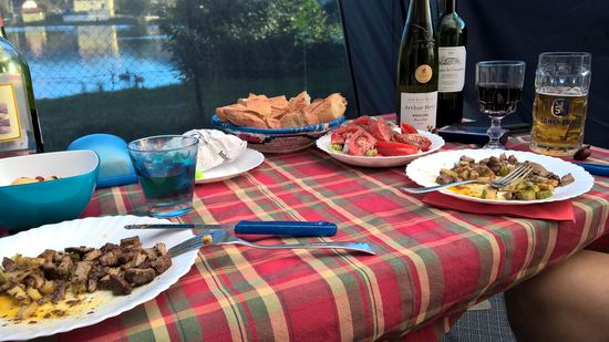 Zum Abendessen gibt es Entenbrust, Pilze, Zucchini, Kartoffeln, Salat, Käse, Brot, Trauben, Wein.