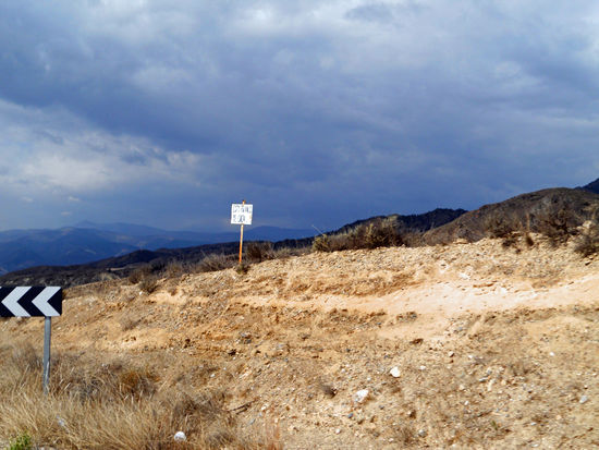 Am Himmel sind dunkle Wolken zu sehen. Die Fahrt geht durch die Sierra de Oria, eine herrliche Gegend, die uns an Landschaften in den USA erinnert. Die Sierra de Oria gehört zu der Bergkette Sierra de las Estancias.