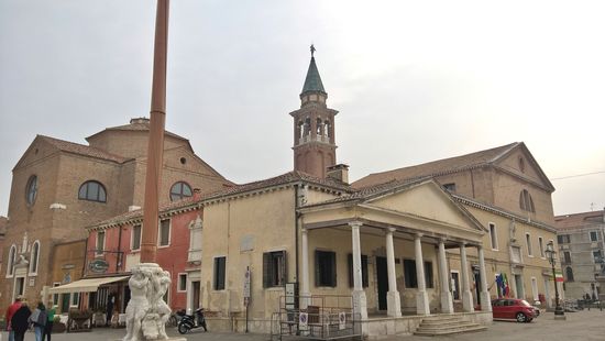 Standarte – Stendardo. Der Marmorsockel, der die Standarte trägt, es handelt sich hier um drei Zyklonen, denen der Volksmund eindrucksvolle Namen gegeben hat. Rechts daneben Loggia dei Bandi