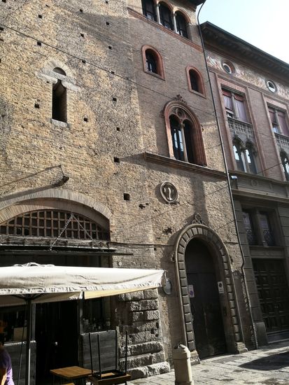 Auf Platz 4 der Piazza della Mercanzia, CASA BOLOGNINI.
Casa Bolognini - Der Alberici-Turm wurde im 12. Jahrhundert in die Fassade integriert. 1273 wurde die Öffnung für ein Geschäft geschaffen, als die Turmwände um mehr als zwei Meter dünner wurden. Im Jahr 1357 gehörte es der Familie Bolognini, die hier Seidengeschäfte führte. Im Inneren befindet sich eine anmutige Treppe aus dem 16. Jahrhundert.