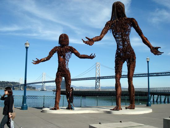 Zwei Skulpturen mit einem Teil der Bay Bridge im Hintergrund