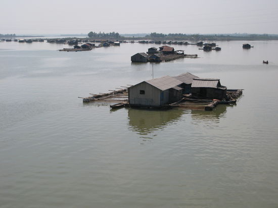 schwimmende haeuser der fischer auf dem fluss. hier wird gelebt, gearbeitet, geschlafen. die kinder werden mit dem boot zur schule abgeholt.