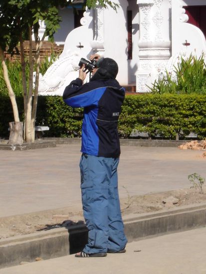 NEIN - er fotografiert nicht am Mount Everest... in Skimuetze und Skihose, immer noch bei 30 Grad