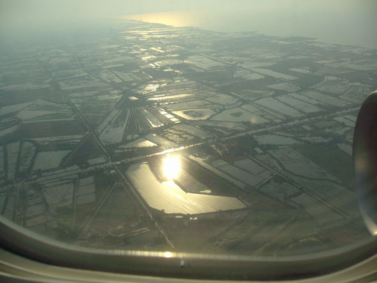 Anflug auf den Flughafen in Bangkok über Reisfelder.
