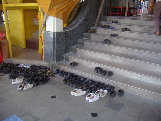 vor dem Betreten eines Tempels Schühchen aus.