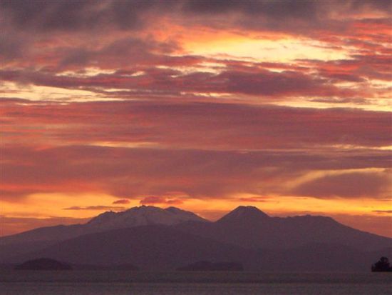 Sonnenuntergang am Lake Taupo, mit den Vulkanen des Tongariro NP im Hintergrund.