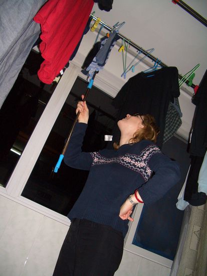die Wäschestangen im geschlossenen Balkon hängen so hoch, dass es einen Stab gibt, mit dem man als kleine/re Person die Bügel nach oben balancieren kann.