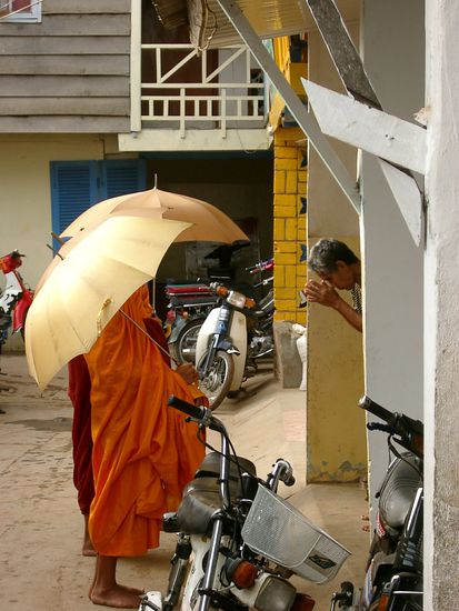 3 Mönche beim traditionellen Frühstück-Beschaffungs-Gang. Nach erhaltener Spende (Essen oder Geld) empfängt der Spender in Demut einen im Chor gesungenen Segen.
Auch ich trage meinen Obulus bei, verstehe jedoch leider kein Wort von dem Gesinge.