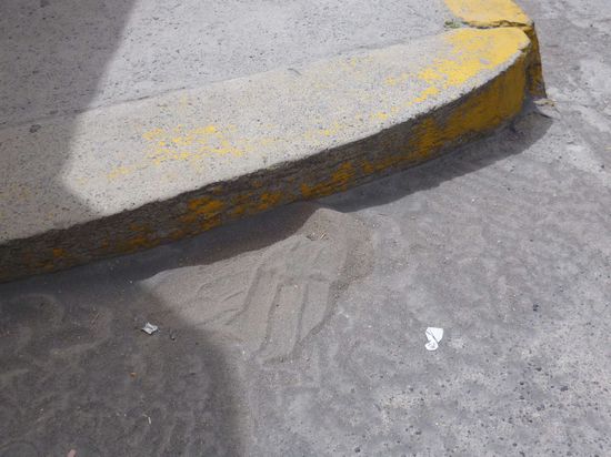 Asche-Verwehungen am Straßenrand.