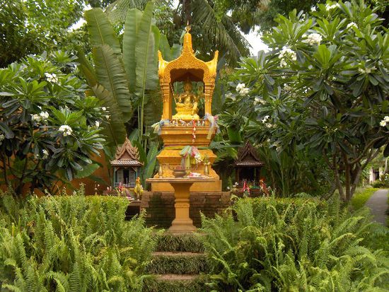 Sicht von vorne auf das Geisterhaus des Anantara.
Vor jedem Haus in Thailand steht ein solches, nicht immer so pompös aber immerhin. Im Glauben der Thais wurde durch den Neubau eines Gebäudes jemandem etwas weggenommen, damit sich dieser nicht darüber aufregen, stellt man ihnen ein kleines Häuschen hin. Man bringt Opfergaben wie: Cola, Wasser, Räucherstäbchen, etwas zu Essen, Buddhabilder, usw. Geht man weiter so kommt man direkt.....