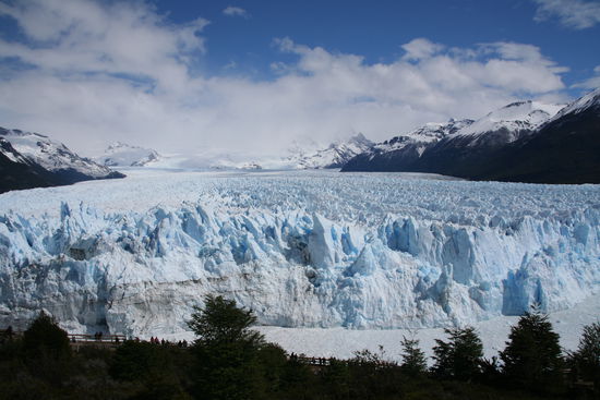 Links vorne sieht man die Menschen und die Besucherterasse und kann die schiere Groesse erahnen
