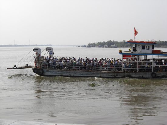 Eine Faehre voller Mopetfahrer auf dem Mekong