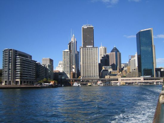 Blick von der Faehre auf Circular Quay,the hub of Sydney Harbour, situated at a small inlet called Sydney Cove, the founding site for Sydney and Australia. Dort ist auch der Terminal mit den Faehren, die von vielen Sydneysidern auch fuer den Weg zur Arbeit und zurueck benutzt werden. Der Faehrterminal ist am unteren Ende des Central Business District (CBD)