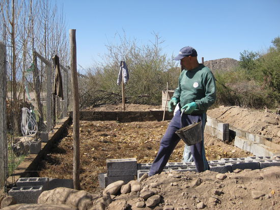 Das Mauerfundament wird gebaut. Auf der einen Seite entsteht eine hohe Mauer als Schutz vor Wind, Wetter und Staub.